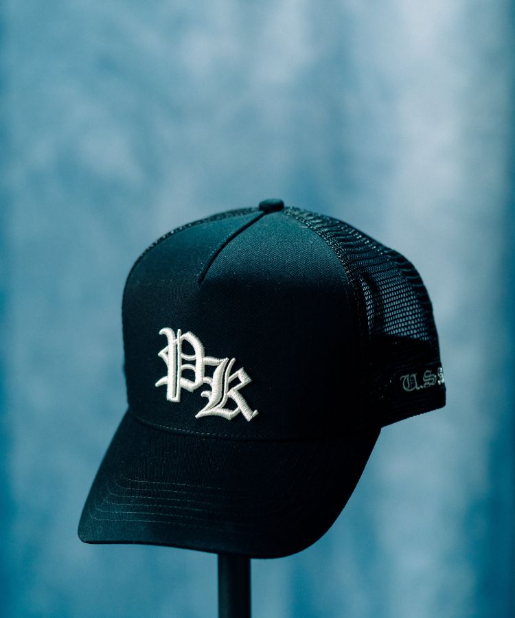 Black PK Cap by Philip Karto with a white logo on a blue background