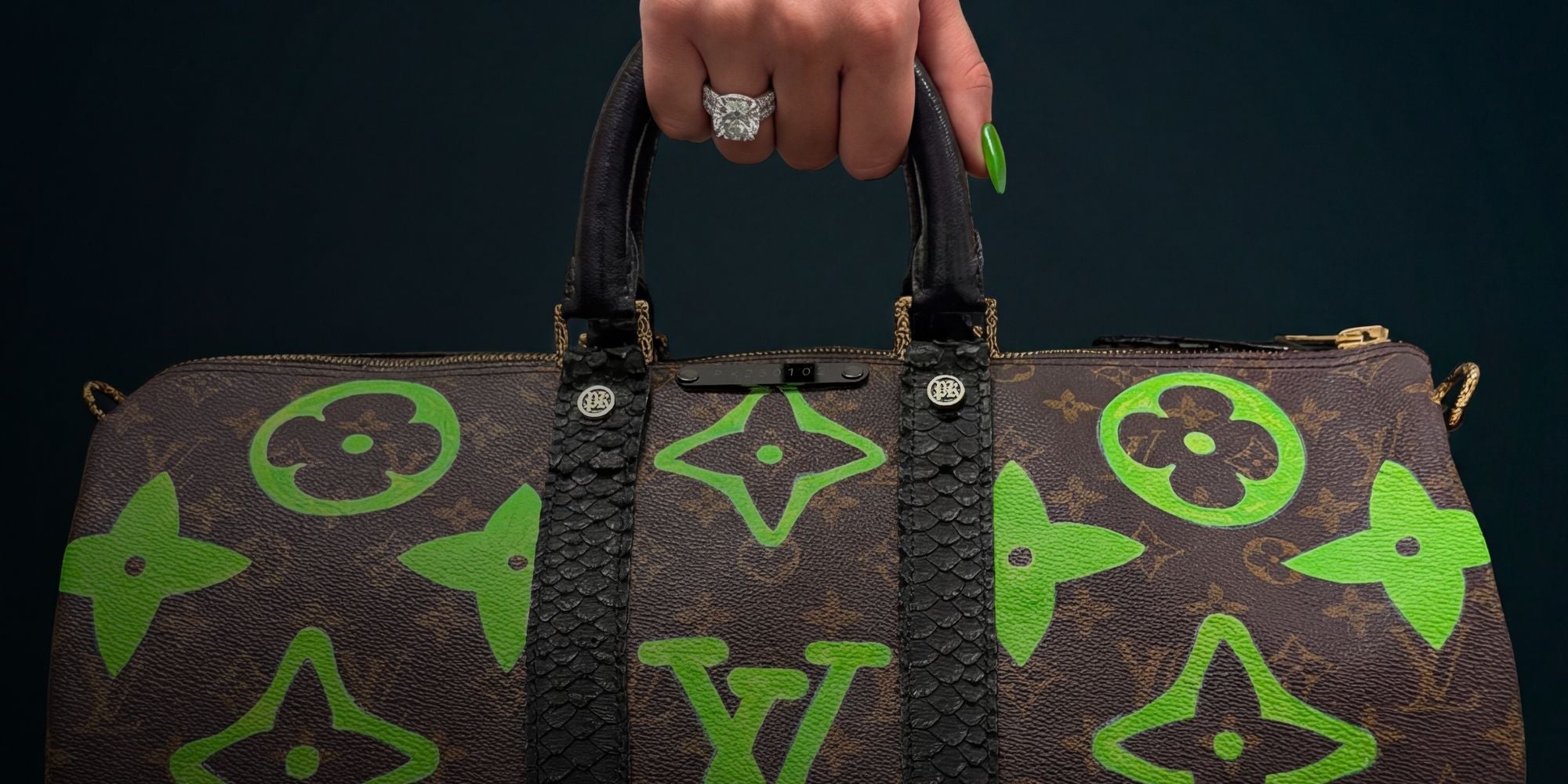 Hand holding a Louis Vuitton Keepall bag by Philip Karto with painted green LV monogram pattern and PK pieces - Luxury vintage transformation