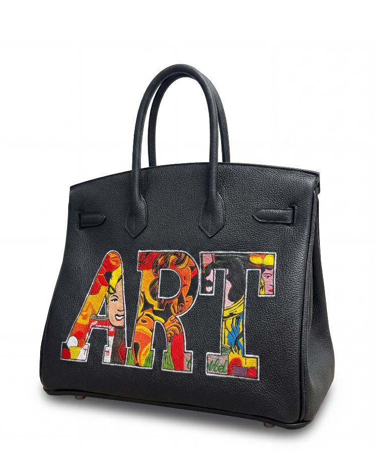 Black handbag with colorful 'ART' design on a white background