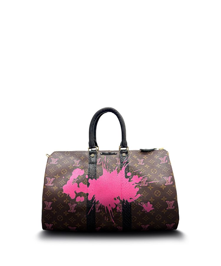 Designer handbag with pink splatter design on a white background