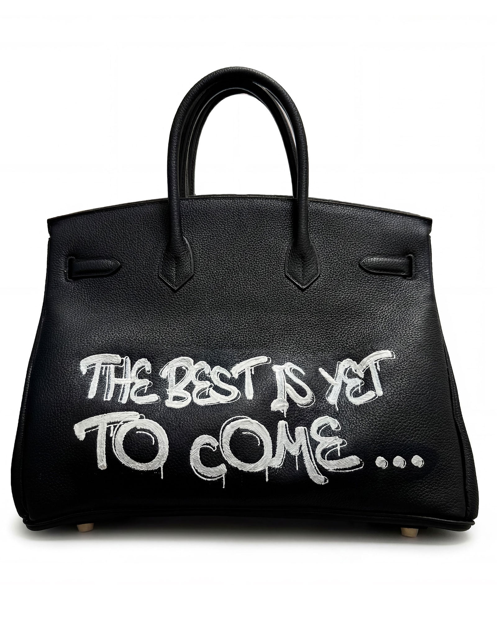 Philip Karto PK.02 The Best Is Yet To Come on bakc side of Birkin bag with white typographic script on black Hermès leather