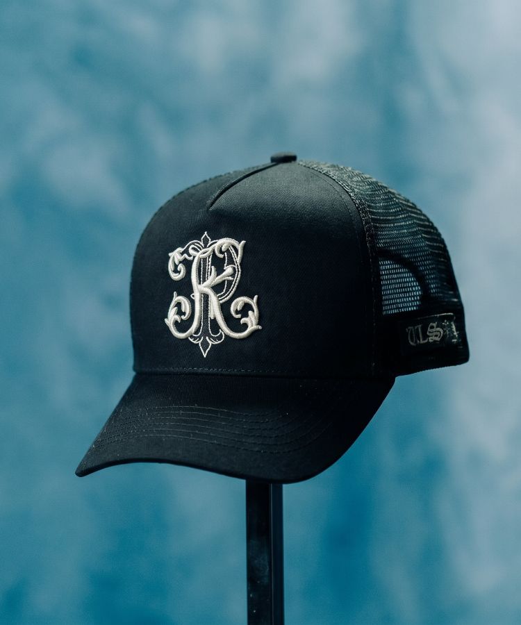 Black Philip Karto cap with white embroidered PK logo on a blue background