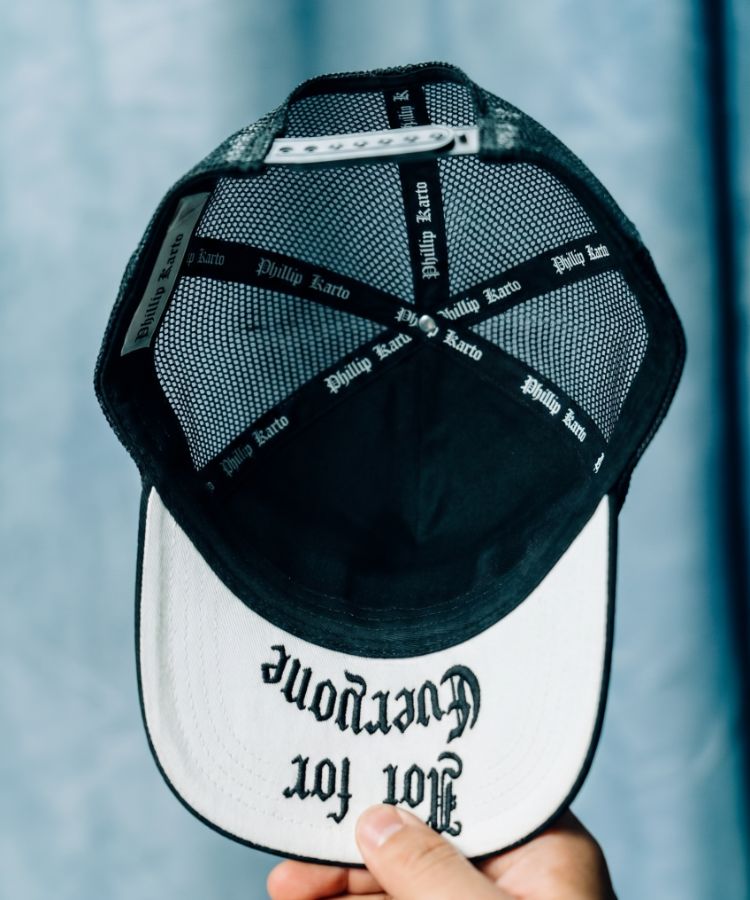 Black and white Not For Everyone cap by Philip Karto with text on a blurred background