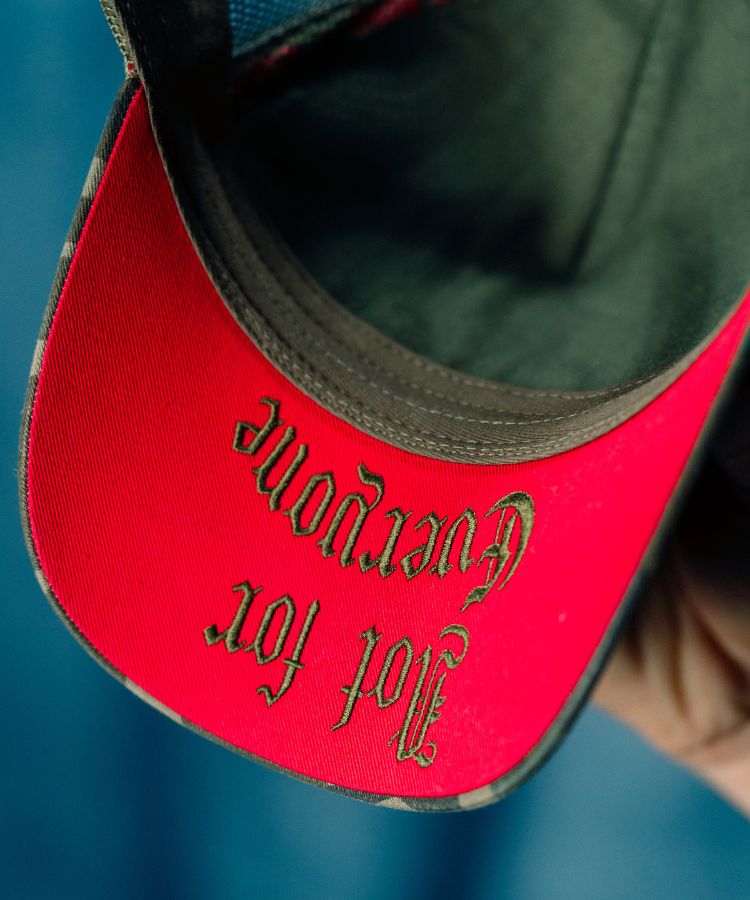 Close-up of Camouflage PK Cap "Not For Everyone" Model by Philip Karto red visor with text on a blue background