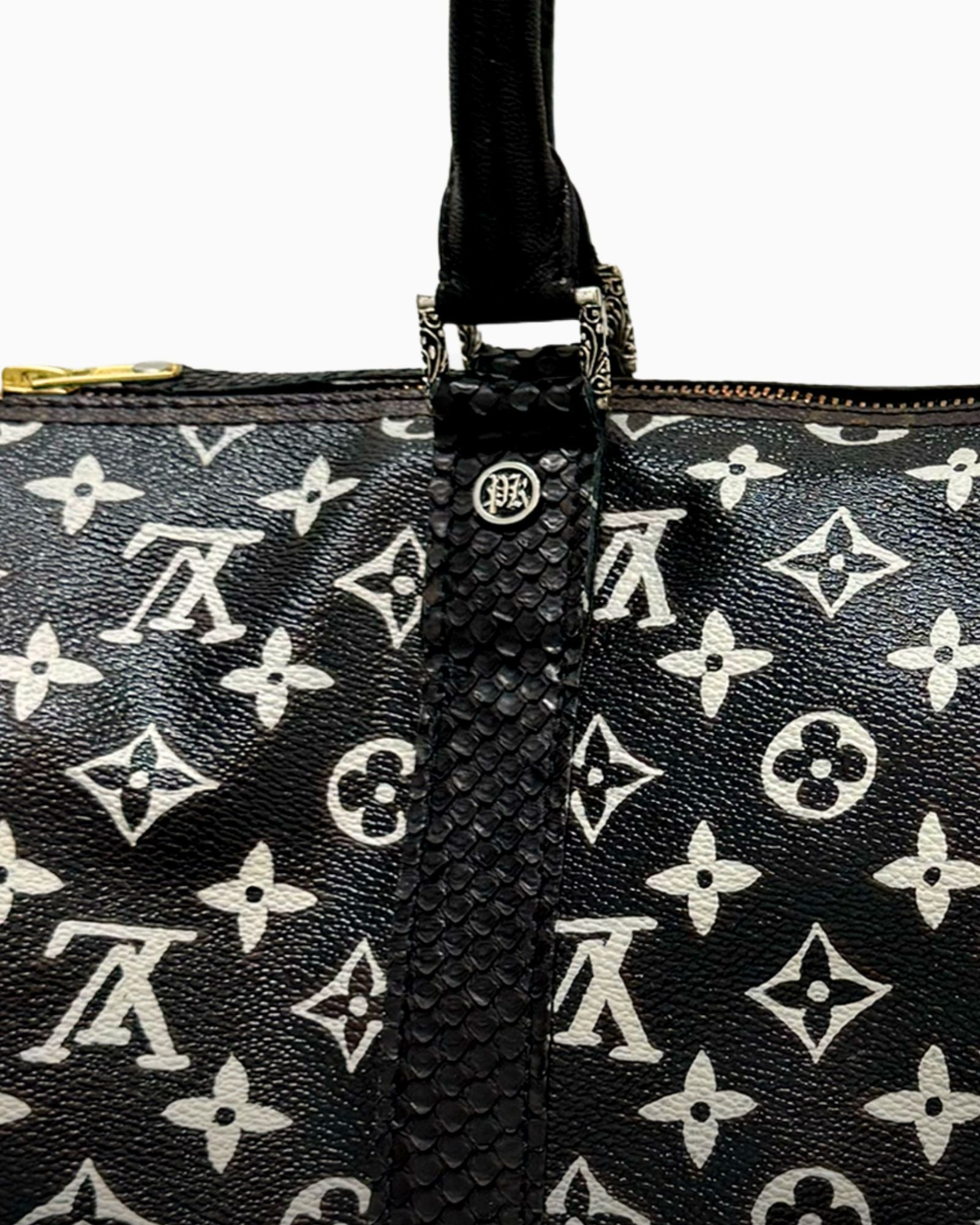 Details of the Philip Karto model Simple Black on a Keepall Vuitton bag showing the monogram in white on a black textured canvas and the Pk grommet and handles.