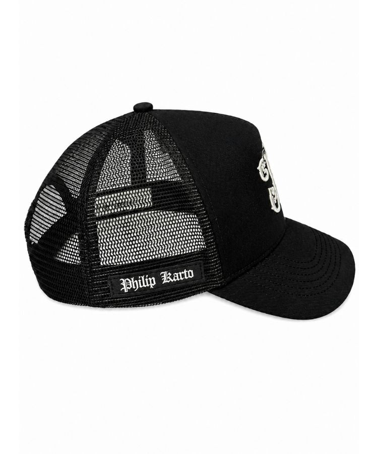 A black trucker-style cap with a curved brim, black mesh back panels, and white embroidered text reading 'Philip Karto' on the side and back mesh from the Not For Everyone collection by Philip Karto.