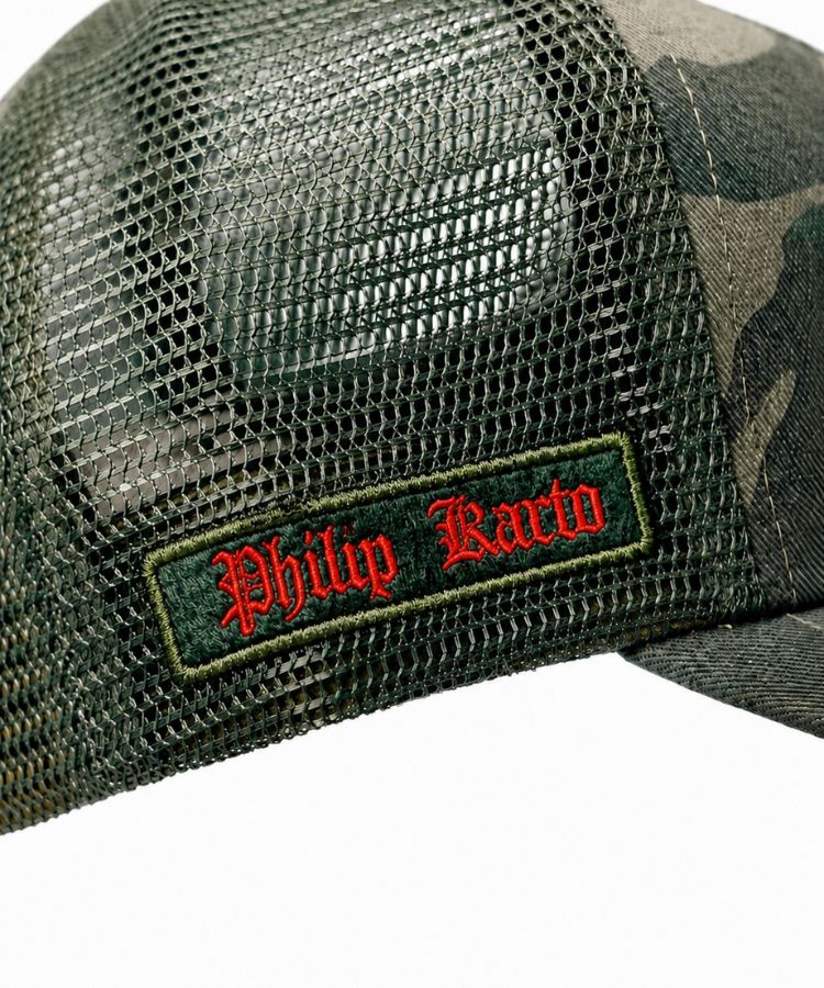 Close-up of Camouflage PK Cap "Not For Everyone" Model by Philip Karto with 'Phillip Kardo' logo against a blue background