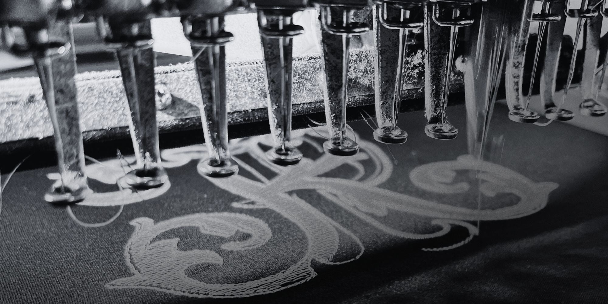 Details of the sewing machine performing an embroidery of the PK logo in the Philip Karto Atelier 