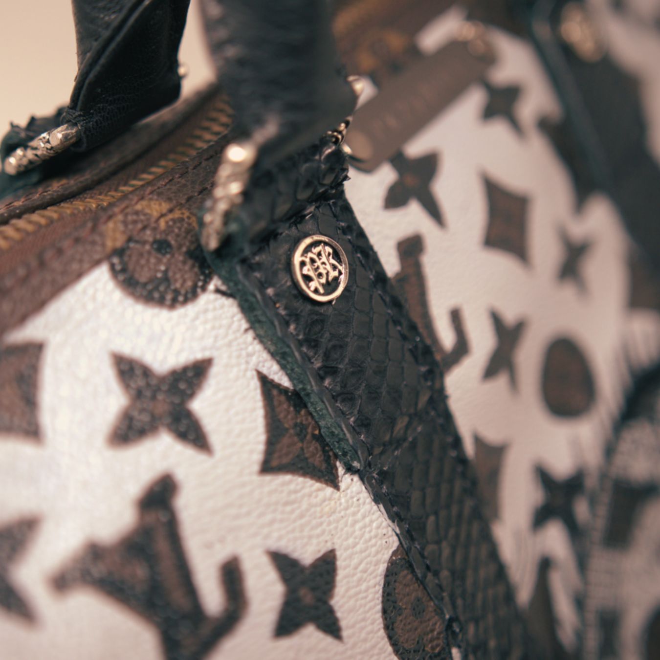 Close-up of a Phili Karto Louis Vuitton bag handbag with monogram and gold emblem.